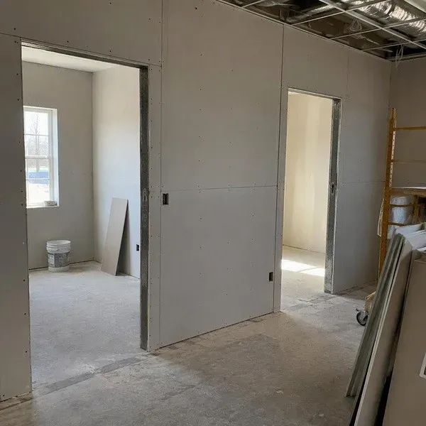 Commercial drywall partitions framed around door openings in a rated corridor