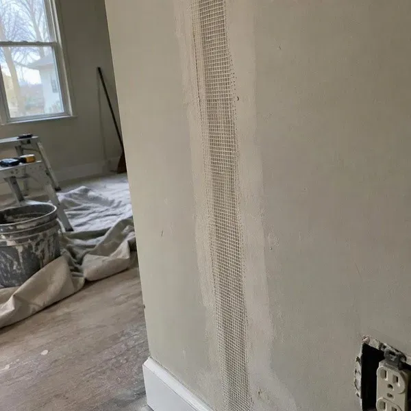 Drywall crack repair with tape embedded over the crack before joint compound