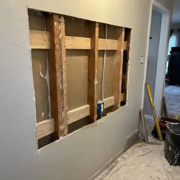 Large drywall hole repair opening cut back to the studs with wood backing strips installed