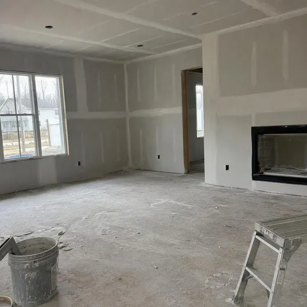 Living room drywall taped around a fireplace in a custom home