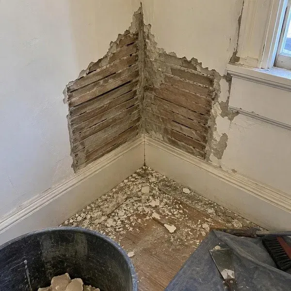 Loose plaster removed at an interior corner with work area contained