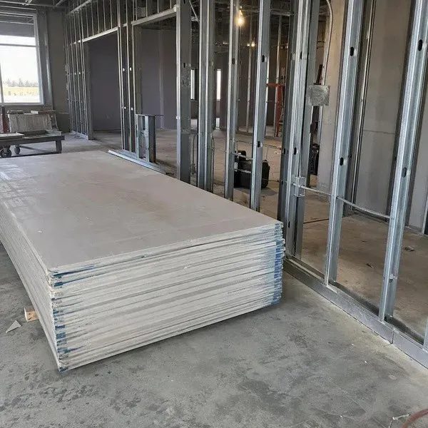 Metal stud framing in an office build-out with drywall sheets staged