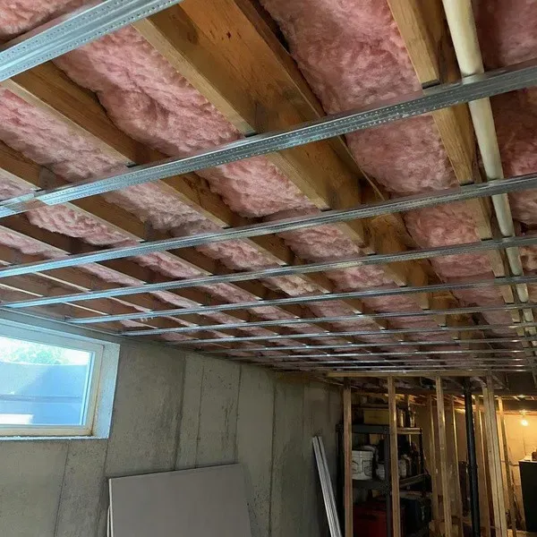 Resilient channel installed across a basement ceiling for soundproofing