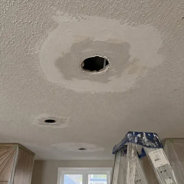 Textured ceiling repaired around an enlarged light opening